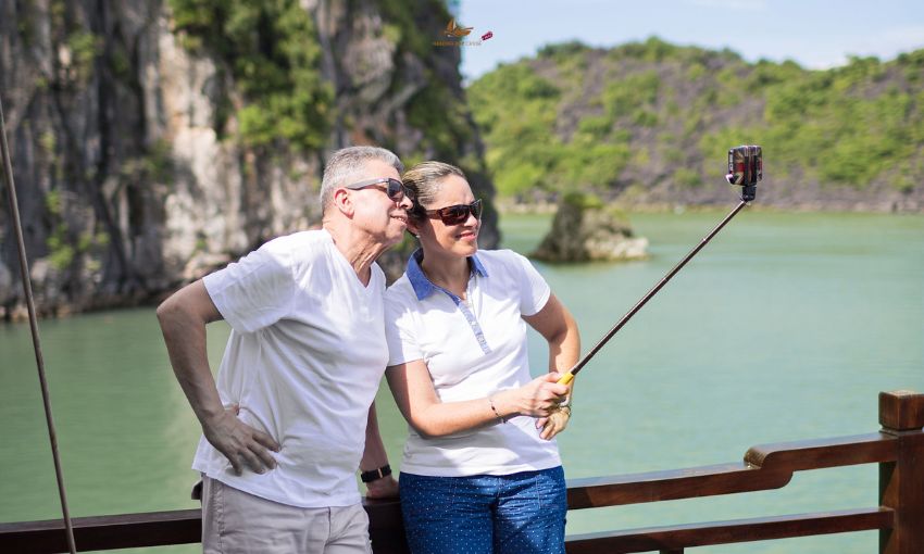A couple of tourists taking pictures on Halong Bay Cruise Deals